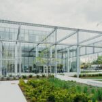 A Metal Structure With a Glass Building Facade at the Back