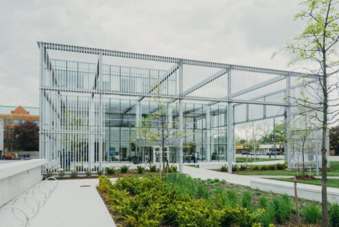 A Metal Structure With a Glass Building Facade at the Back