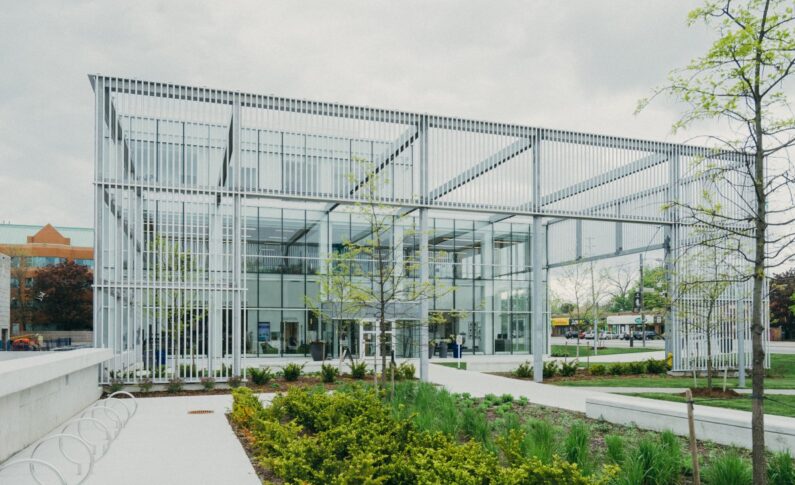 A Metal Structure With a Glass Building Facade at the Back